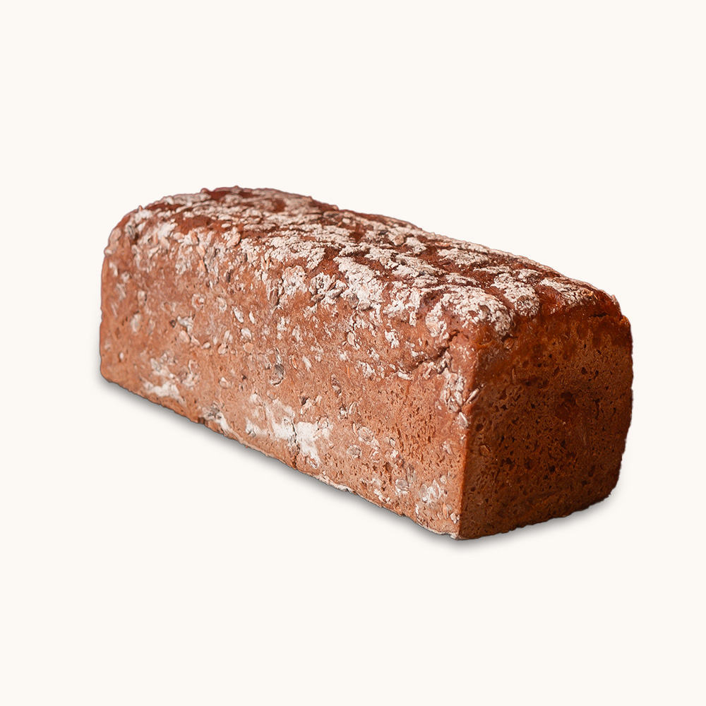 Dunkles, eckiges Kastenbrot mit bemehlter Kruste auf hellem Hintergrund.</p>
<p>