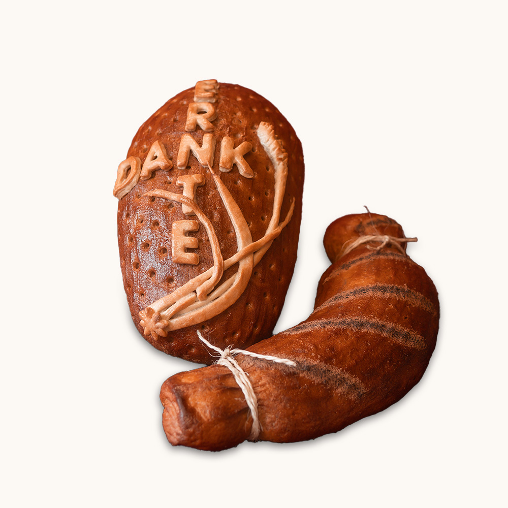 Zwei kunstvoll gebackene Schaubrote, eines mit dem Wort „Erntedank“ und Getreide-Relief, das andere in Form eines gebundenen Horns.