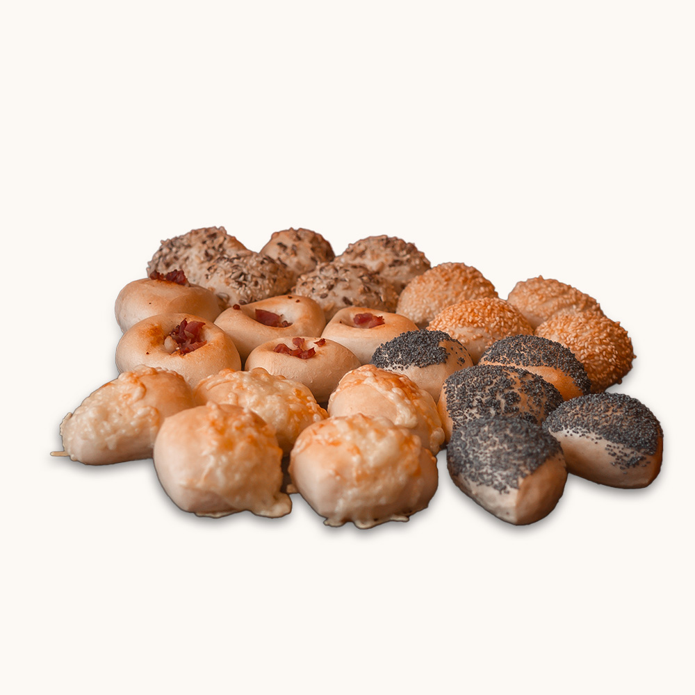 Bunte Auswahl kleiner Partybrötchen mit verschiedenen Belägen wie Mohn, Sesam, Käse, Speck und Körnern.