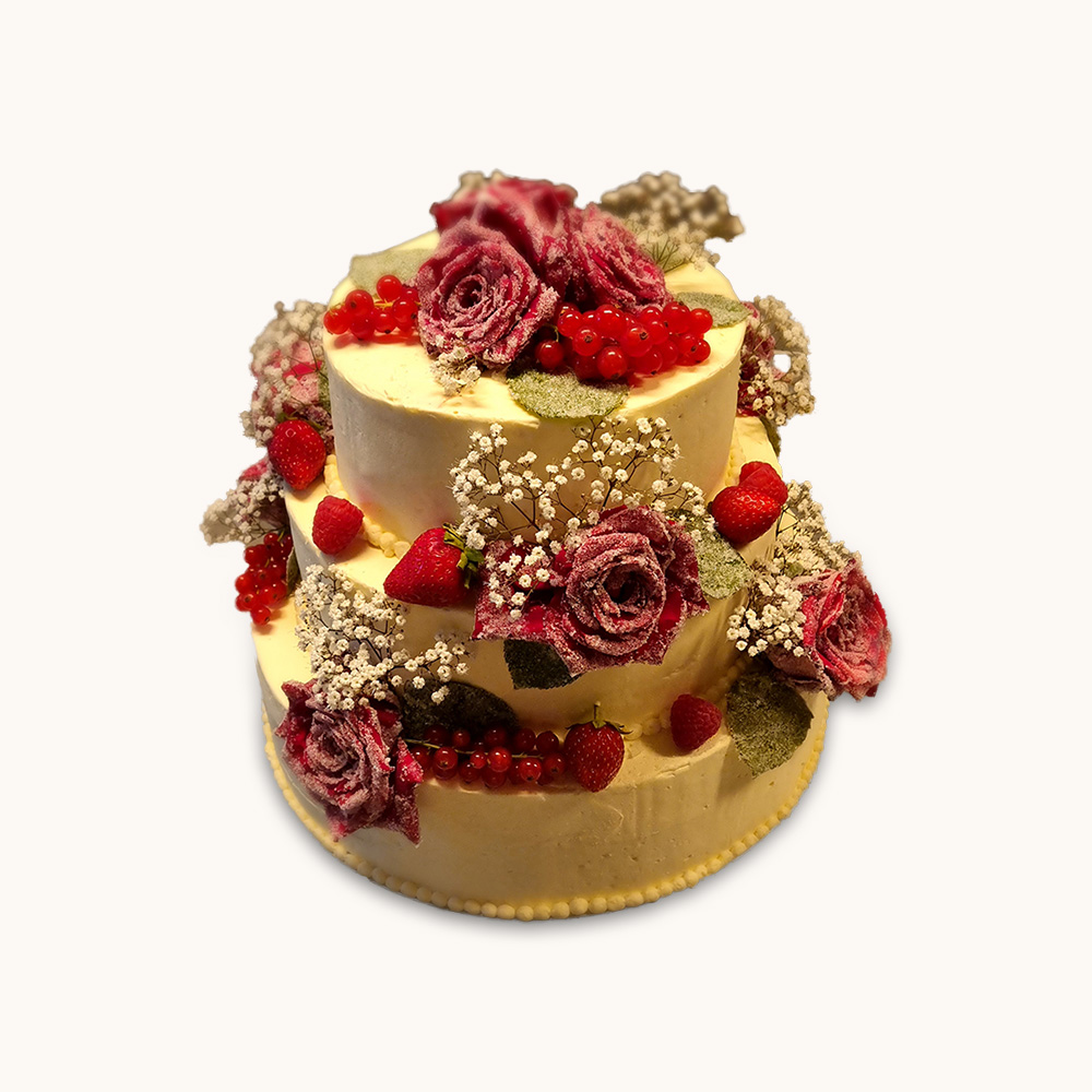 Dreistöckige Hochzeitstorte mit Beeren und kandierten Blüten